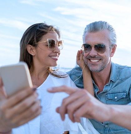 A man and woman using internet for yachts, video chatting on a smart phone